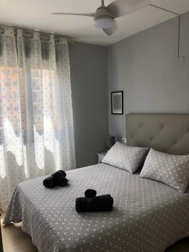 - une chambre avec un lit et 2 serviettes noires dans l'établissement Relajate junto al mar en apartamento Cala Alta, à La Cala de Finestra