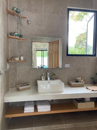 a bathroom with a sink and a mirror at Casa Arena Cozumel in Cozumel