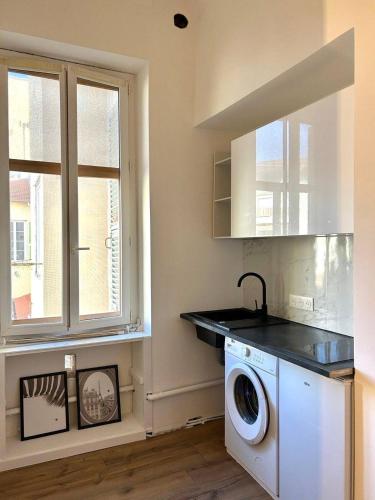a laundry room with a washing machine and a window at Designed flat in Menton center in Menton