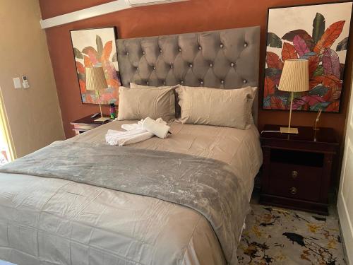 a bedroom with a large bed with two towels on it at Mokapelo Life Style Guest House in Bela-Bela