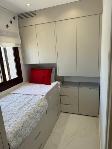 a bedroom with white cabinets and a bed with a red pillow at Kabila Plag in Tetouan