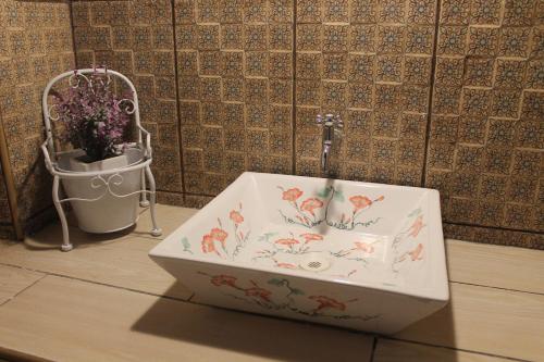 a bathroom sink with fish on it next to a plant at Epoca Iquitos in Iquitos