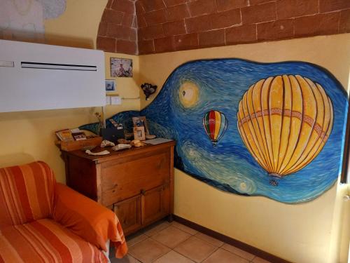 una camera da letto con un dipinto di una mongolfiera di Casa Giulia on Francigena a Gambassi