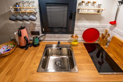 a kitchen with a stainless steel sink and wooden floors at Efe Tiny House in Serik