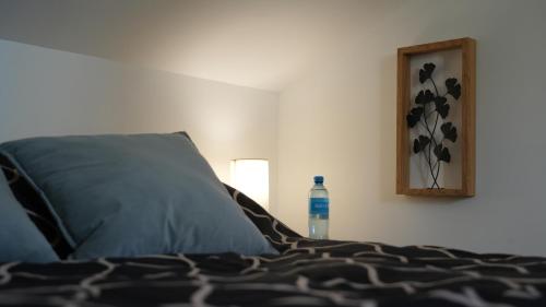 a bedroom with a bed with a bottle of water at * * * Donjon du Bijoutier * * * Wifi+Clim+Terrasse in Beaucaire