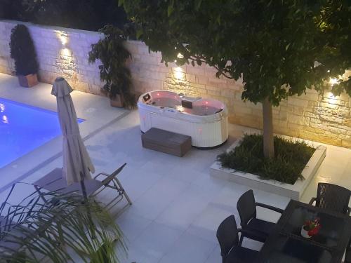 een achtertuin met een hot tub en een tafel en stoelen bij Amare suite in Perivólia