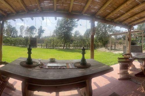 a wooden table sitting on a patio with a view of a yard at Casa de Campo Guayabo Chincha in Chumbiaula