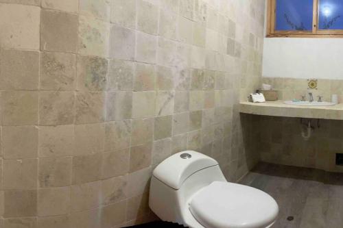 a bathroom with a white toilet and a sink at Casa de Campo Guayabo Chincha in Chumbiaula