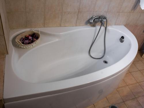 Una bañera blanca con un bol de fruta dentro. en Xenia's House, en Kato Korakiana