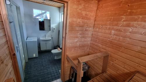 a wooden bathroom with a toilet and a sink at Villa Magnolia 2 Himos in Jämsä