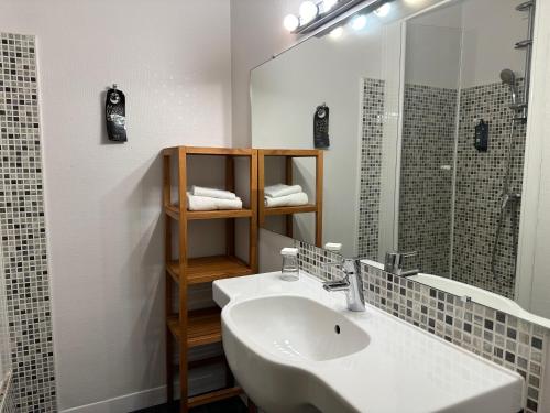 W łazience znajduje się umywalka i lustro. w obiekcie The Originals City, Hôtel Napoléon, La Roche-sur-Yon (Inter-Hotel) w mieście La Roche-sur-Yon
