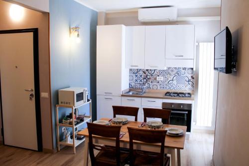 a kitchen with a table and chairs and a kitchen with white cabinets at La Stella di Via Venezia in Marina di Carrara