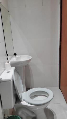 a bathroom with a white toilet and a sink at Loft1 suíte entrada privativa equipado, para até quatro pessoas a 4 minutos do aeroporto de Marabá in Marabá