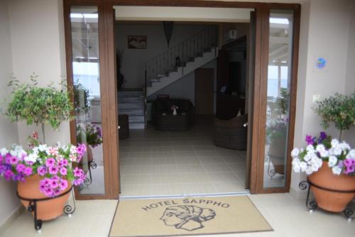 an entrance to a building with pots of flowers at Sappho Hotel in Skala Eresou