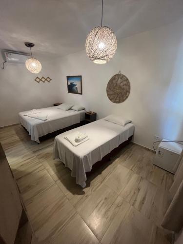 a room with two beds and two chandeliers at Pousada Terra das Águas Barreirinhas in Barreirinhas