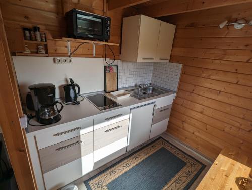 una pequeña cocina con fregadero y microondas en Ferienhaus 2, en Ludorf