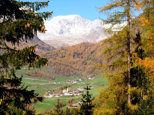 a village in a valley with a snow covered mountain at Cafe Schneider in Lappago