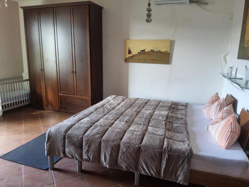 een slaapkamer met een bed en een houten kast bij Cesare Battisti in Seggiano