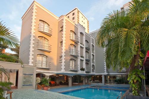 un hotel con piscina frente a un edificio en Country International Hotel, en Barranquilla