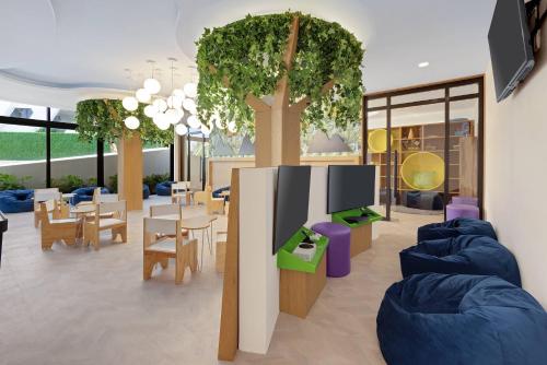 Wyndham Grand Cancun All Inclusive Resort & Villas في كانكون: غرفة معيشة بها طاولات وكراسي وأشجار