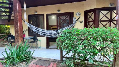 a hammock hanging outside of a house at Casa Maresias Canto do mar - 50m da praia in Maresias