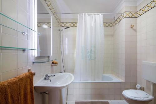 a bathroom with a sink and a toilet and a shower at Family Beach View - Praia da Rocha in Portimão