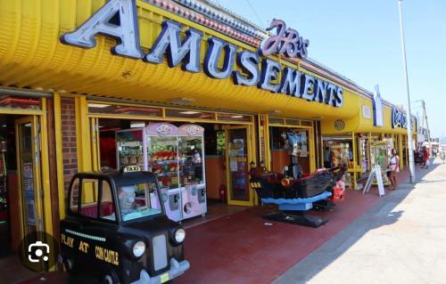 a yellow store front of a store with a monopoly at The Cosy Summer House in Leysdown-on-Sea
