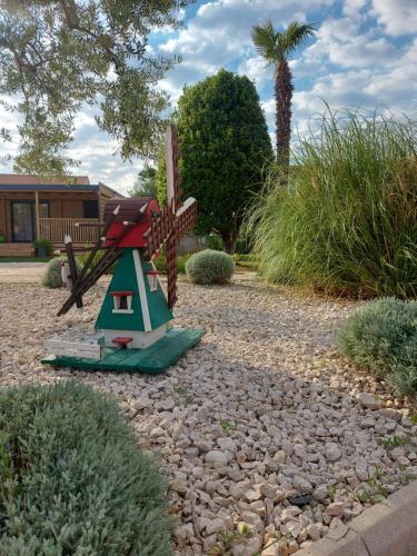 a garden with a bird house in the middle of a yard at Julija Mobile Lux in Vodice