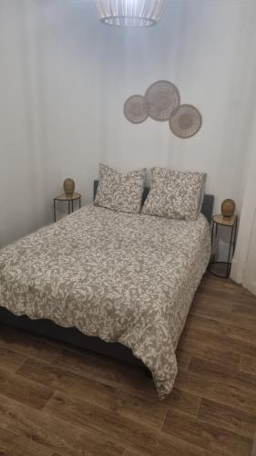 - une chambre avec un lit avec une couette et 2 tables dans l'établissement Maison Cocon, à Pantin