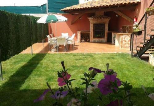 a backyard with a table and an umbrella at El Mirador De Campumedra in Vadillo