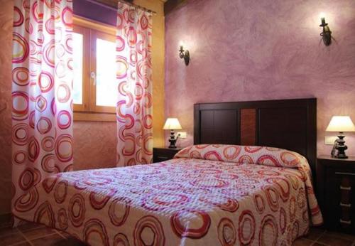 a bedroom with a bed and a window with curtains at El Mirador De Campumedra in Vadillo