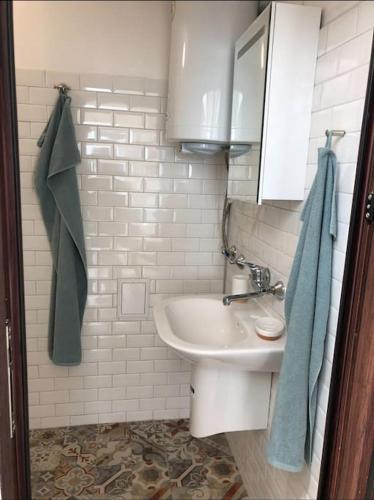 a white bathroom with a sink and a mirror at Studio with a sea view in Balchik