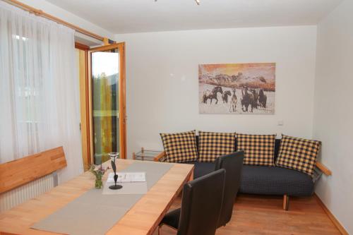 a dining room with a table and a couch at Apartments Alpenfrieden in Sankt Martin am Tennengebirge