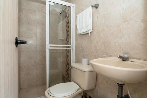 y baño con aseo, lavabo y ducha. en Hotel Imperial House, en Barranquilla