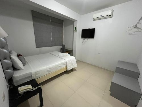 Habitación de hotel con cama y TV en Miskisol, en Piura