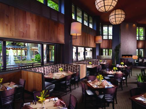 un restaurante con mesas, sillas y ventanas en Omni Hilton Head Oceanfront Resort en Hilton Head Island