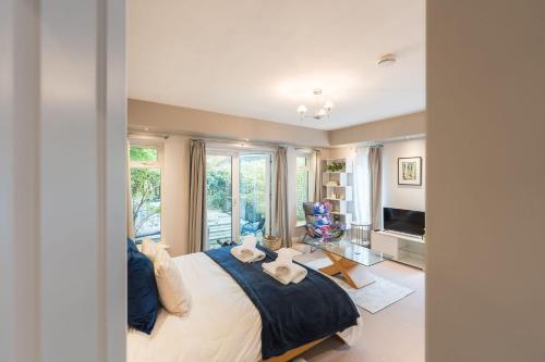a bedroom with a large bed and a television at The Failand Retreat Luxury Stay in Flax Bourton