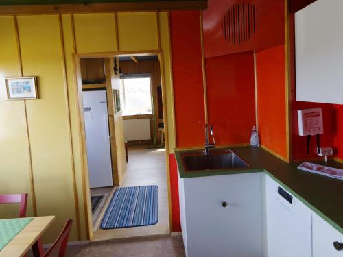a kitchen with orange and yellow walls and a sink at Myvo The House Geiteyjarströnd 4 in Geiteyjarstrond
