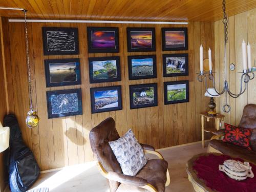 a room with a chair and pictures on the wall at Myvo The House Geiteyjarströnd 4 in Geiteyjarstrond