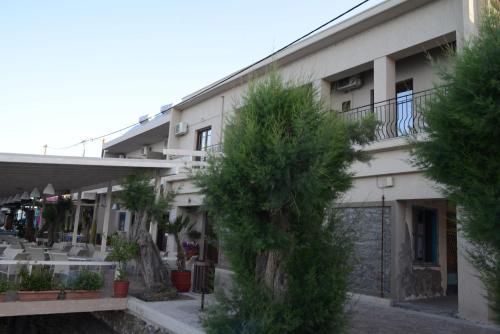 an apartment building with trees in front of it at Sappho Hotel in Skala Eresou