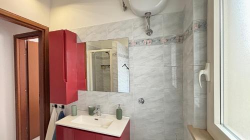 bagno con lavandino e armadietto rosso di Mazzini Bilo Roseto Vacanza a Roseto degli Abruzzi