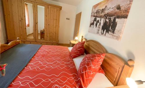 a bedroom with a bed with a red comforter at Apartments Alpenfrieden in Sankt Martin am Tennengebirge