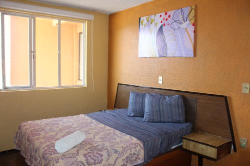 a bedroom with a bed and a window at Hotel Los Diamantes Orizaba in Orizaba