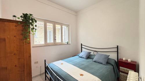 una camera da letto con un letto con cuscini blu e una finestra di Mazzini Bilo Roseto Vacanza a Roseto degli Abruzzi