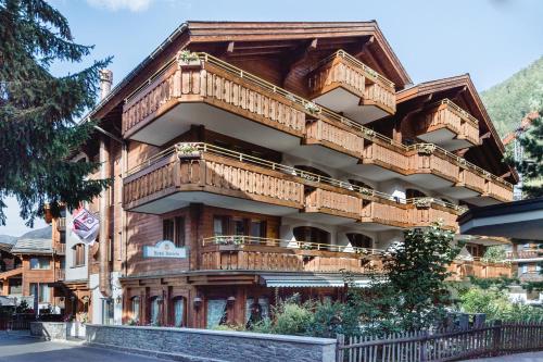 un grand bâtiment en bois avec balcon. dans l'établissement Hotel Daniela, à Zermatt