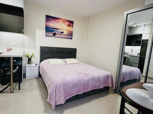 a bedroom with a large bed with a purple blanket at Modern studio in Elliniko 5 mins from metro in Athens