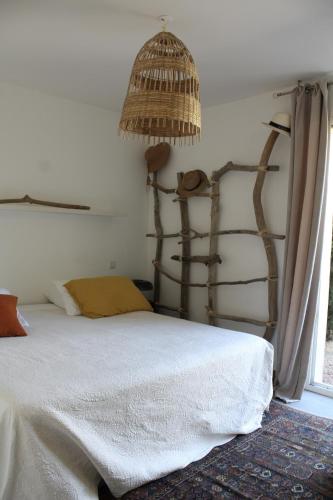 une chambre avec un lit avec une tête de lit en rotin dans l'établissement Appartement Le Pinarello, à Sainte-Lucie de Porto-Vecchio