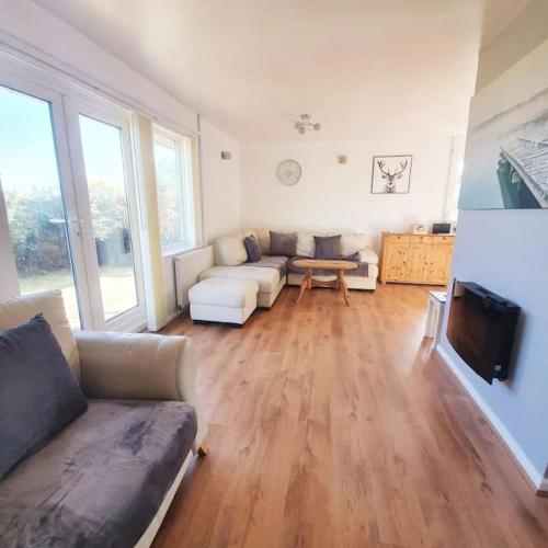 a living room with a couch and a tv at Seaview Self Catering-Fleetview in Weymouth