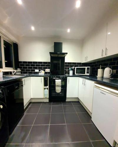 a kitchen with white cabinets and a stove in it at Seaview Self Catering-Fleetview in Weymouth