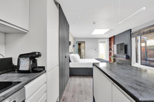 a white kitchen with a bed in a room at Skyline Studios in London